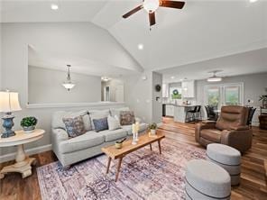 living room with lofted ceiling, hardwood / wood-style flooring, and ceiling fan