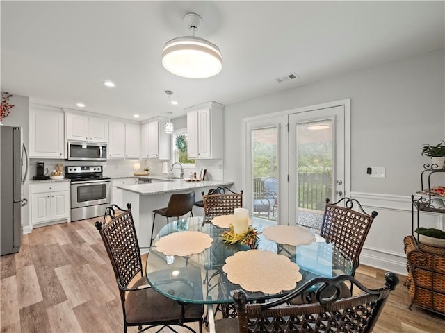 dining room featuring sink and light wood-type flooring