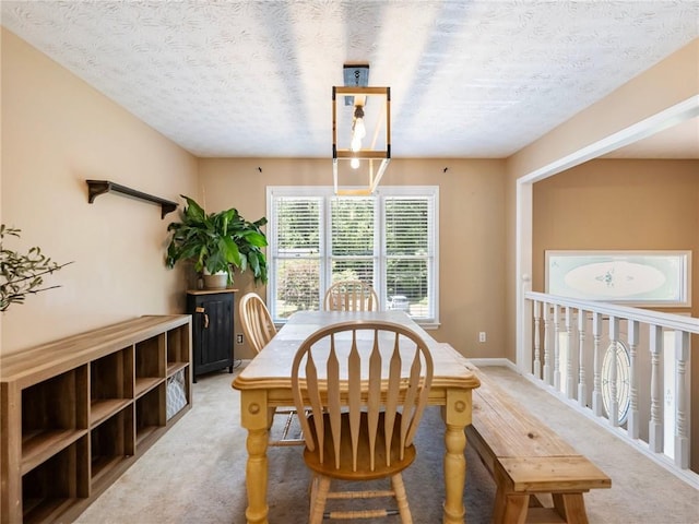 dining area with a textured ceiling and light carpet