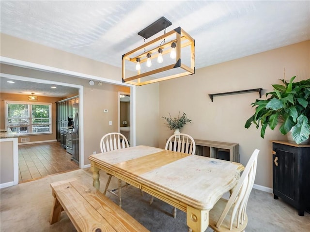 dining space with baseboards and light wood-style flooring