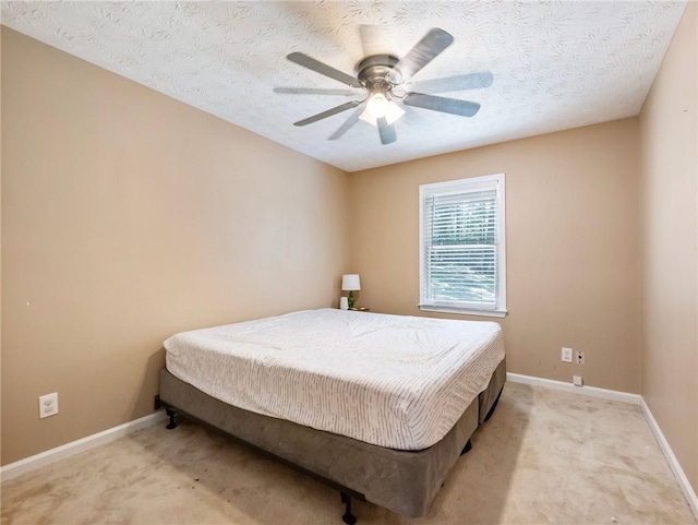 bedroom featuring light colored carpet, baseboards, a textured ceiling, and ceiling fan