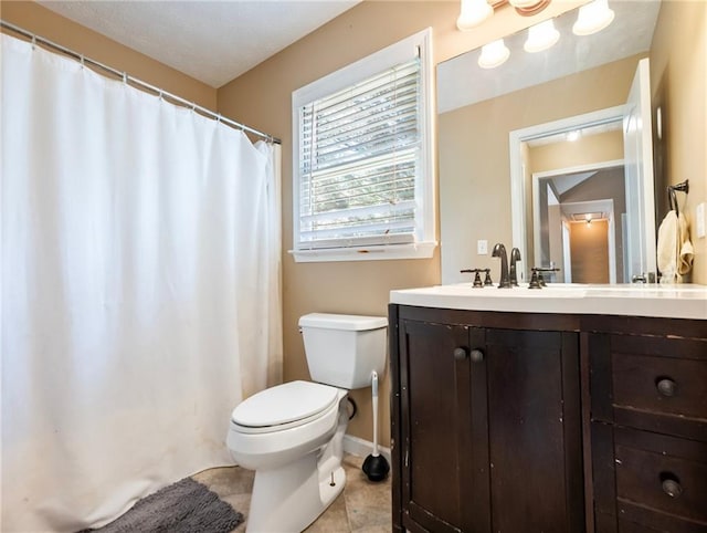 full bathroom featuring toilet, vanity, tile patterned flooring, and baseboards