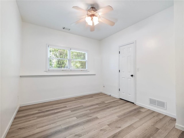 empty room with light wood-style flooring, a ceiling fan, and baseboards