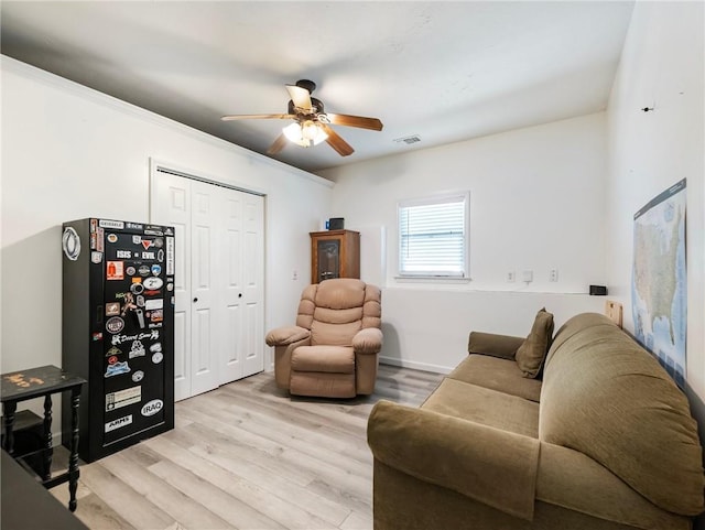 living room with ceiling fan and light wood-style flooring