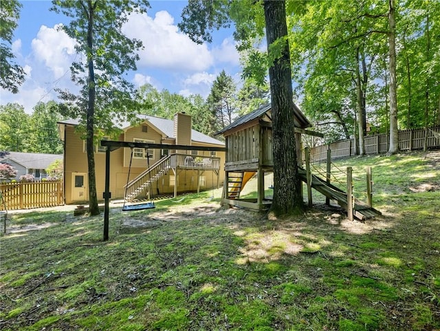 view of playground with stairway, a fenced backyard, and a wooden deck