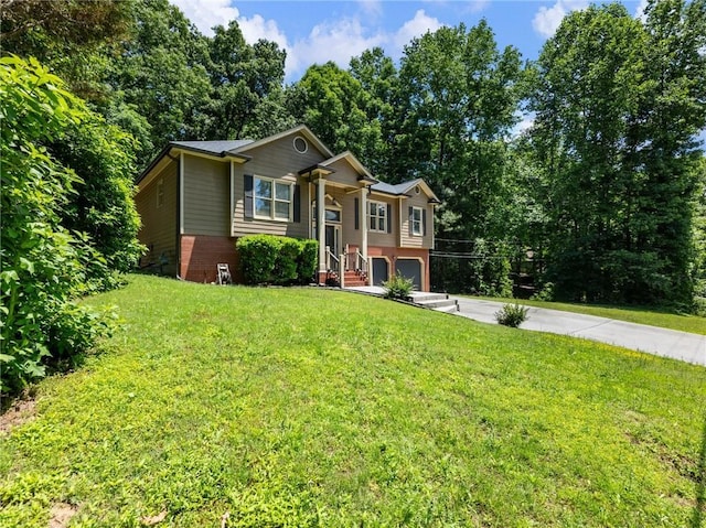 split foyer home with driveway, an attached garage, a front lawn, and brick siding