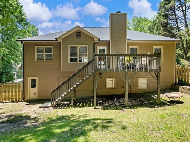 back of property with stairs, a chimney, a wooden deck, and roof with shingles