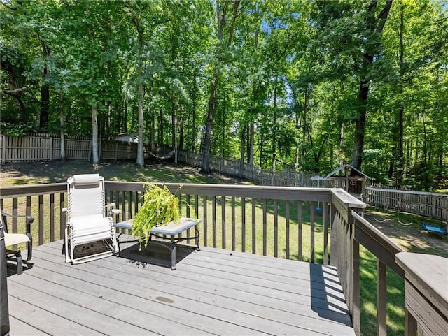 wooden deck featuring a playground and view of scattered trees