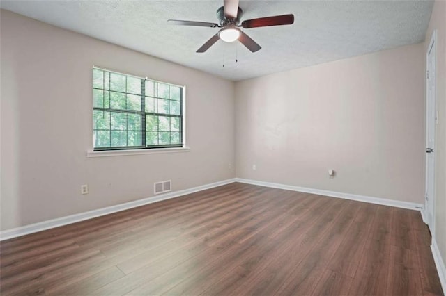 unfurnished room with a textured ceiling, dark wood-type flooring, and ceiling fan