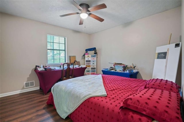 bedroom with a textured ceiling, dark wood-type flooring, and ceiling fan