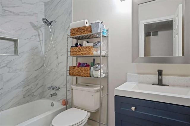 full bathroom featuring vanity, tiled shower / bath combo, and toilet