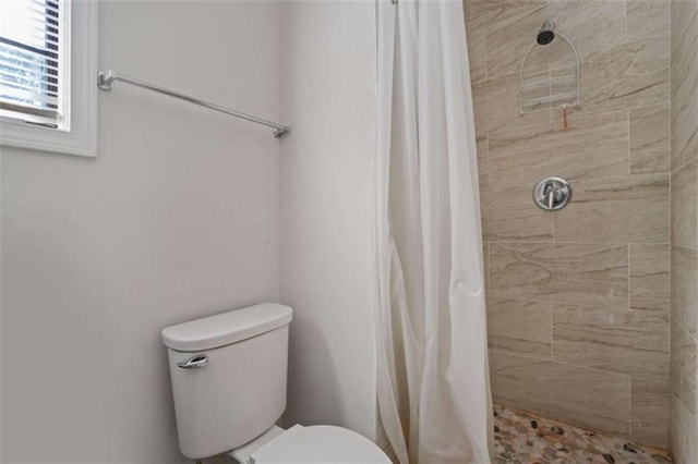 bathroom featuring curtained shower and toilet