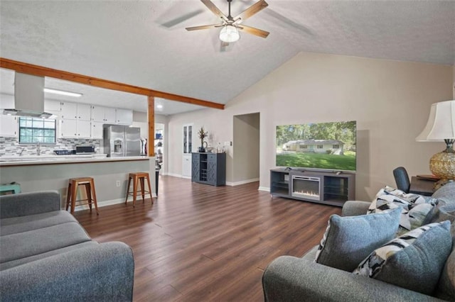 living room featuring dark wood-type flooring, sink, lofted ceiling with beams, a textured ceiling, and ceiling fan