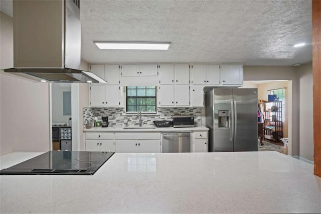 kitchen featuring ventilation hood, white cabinetry, sink, decorative backsplash, and stainless steel appliances