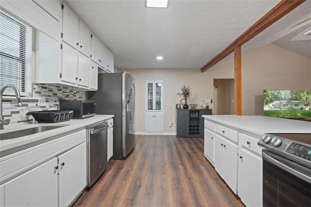 kitchen featuring appliances with stainless steel finishes, sink, white cabinets, dark hardwood / wood-style flooring, and backsplash