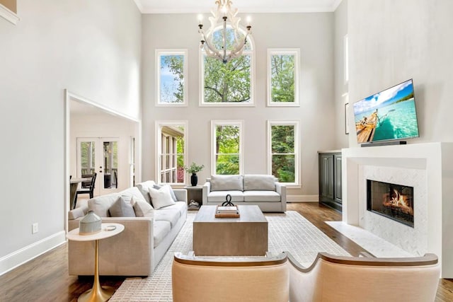 3925 Sheldon Dr NE, Atlanta, GA 30342 - living room featuring a high ceiling, wood finished floors, a fireplace with flush hearth, baseboards, and french doors