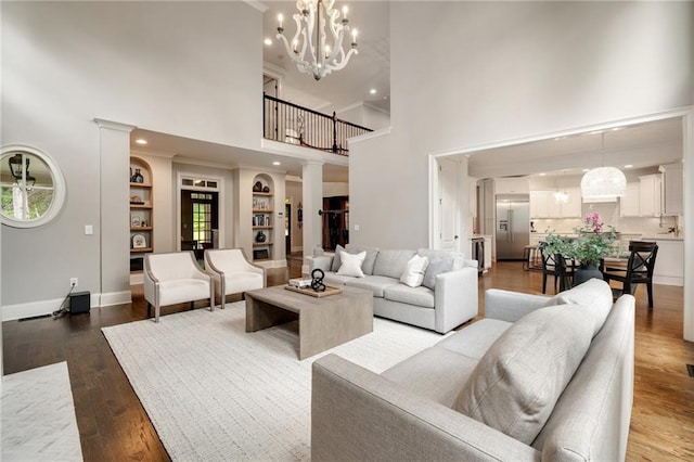 3925 Sheldon Dr NE, Atlanta, GA 30342 - living room with a high ceiling, a chandelier, wood finished floors, baseboards, and built in features