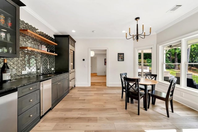 3925 Sheldon Dr NE, Atlanta, GA 30342 - dining room featuring bar with sink, a chandelier, ornamental molding, light wood-type flooring, and recessed lighting