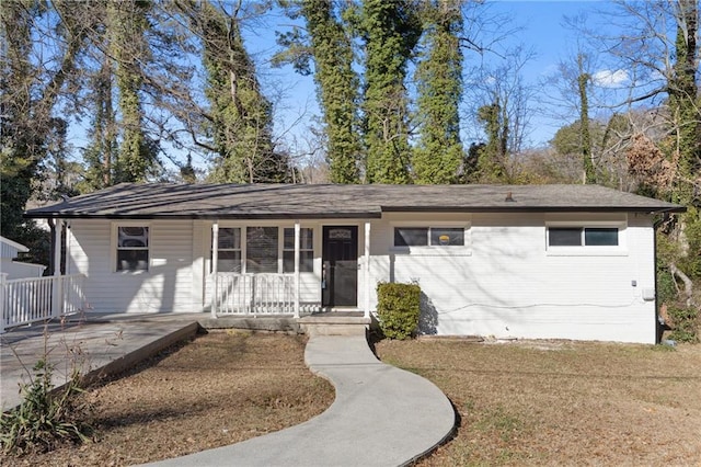 ranch-style house with a porch and a front yard