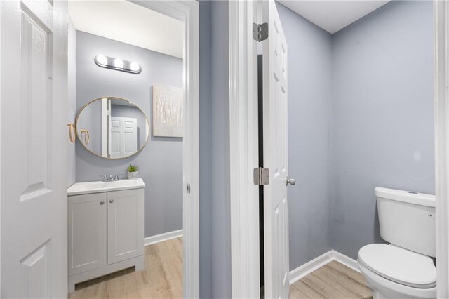 bathroom featuring vanity, toilet, and hardwood / wood-style floors