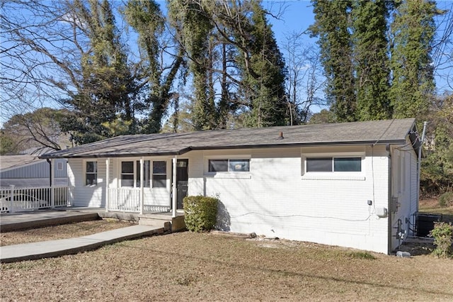 view of front of home featuring central AC, a front yard, and a porch