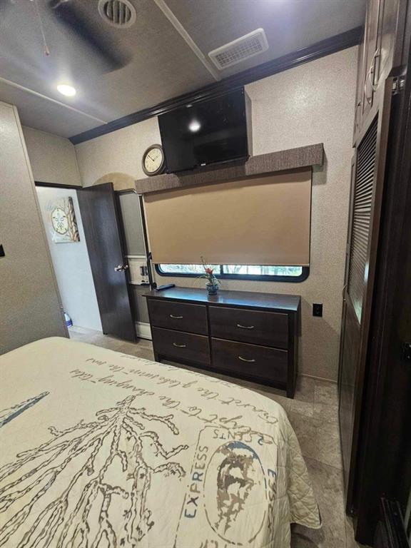 bedroom featuring ceiling fan and tile patterned floors