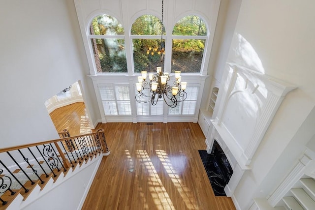 entrance foyer featuring a towering ceiling, a notable chandelier, and hardwood / wood-style flooring