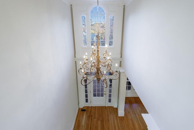 interior details with hardwood / wood-style floors, a notable chandelier, and crown molding