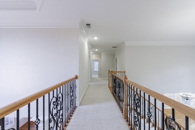 corridor featuring a healthy amount of sunlight, light colored carpet, and ornamental molding