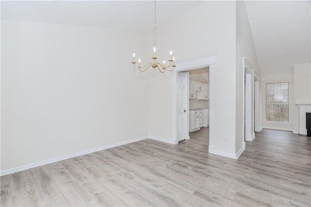 unfurnished dining area with an inviting chandelier and light hardwood / wood-style floors