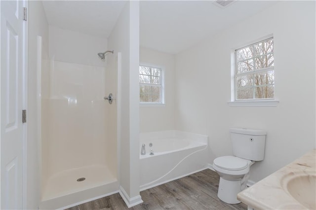 full bathroom with hardwood / wood-style flooring, separate shower and tub, sink, and toilet