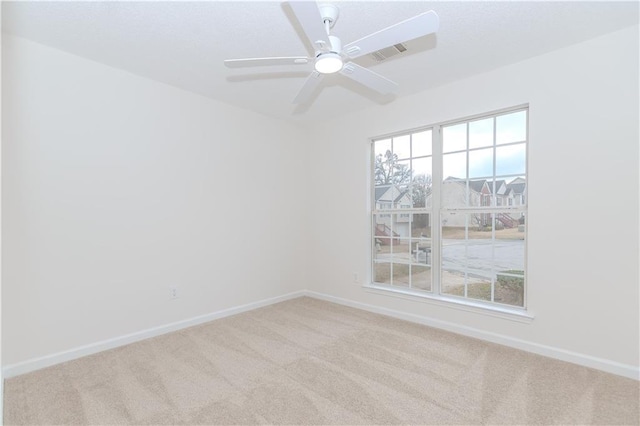 spare room with ceiling fan and light colored carpet