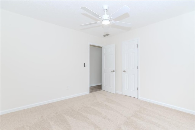 carpeted spare room featuring ceiling fan