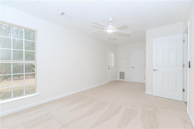 carpeted spare room with ceiling fan