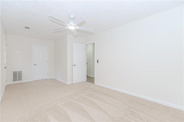 spare room featuring ceiling fan and light carpet