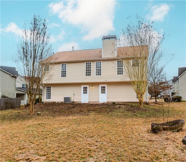 rear view of property with a yard and central air condition unit