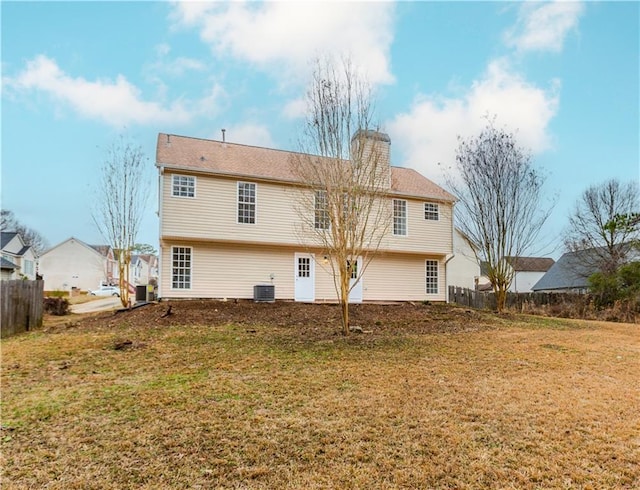 back of property with a yard and central air condition unit