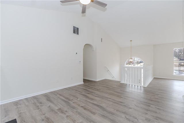 empty room with light hardwood / wood-style flooring, high vaulted ceiling, and ceiling fan