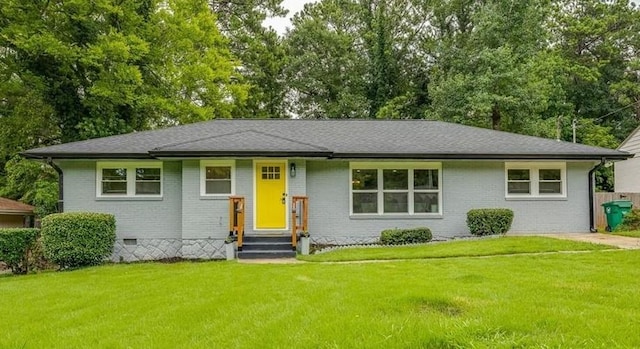 view of front facade with entry steps, brick siding, roof with shingles, crawl space, and a front lawn