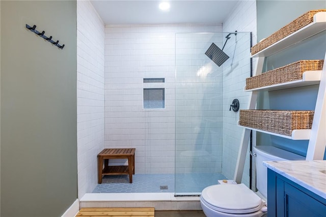 full bath featuring vanity, a tile shower, and toilet