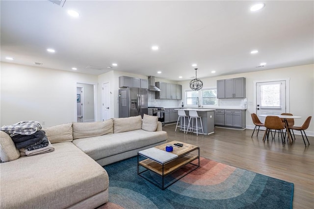 living room with recessed lighting, dark wood finished floors, and baseboards