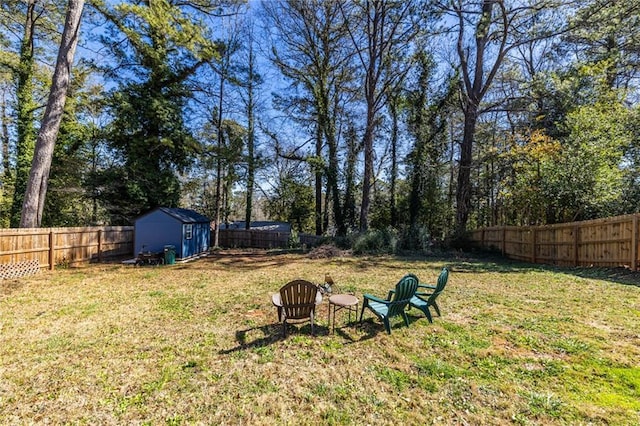 view of yard featuring an outbuilding, a fenced backyard, and a storage shed