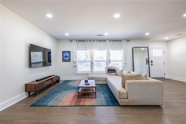 living room with baseboards, wood finished floors, visible vents, and recessed lighting