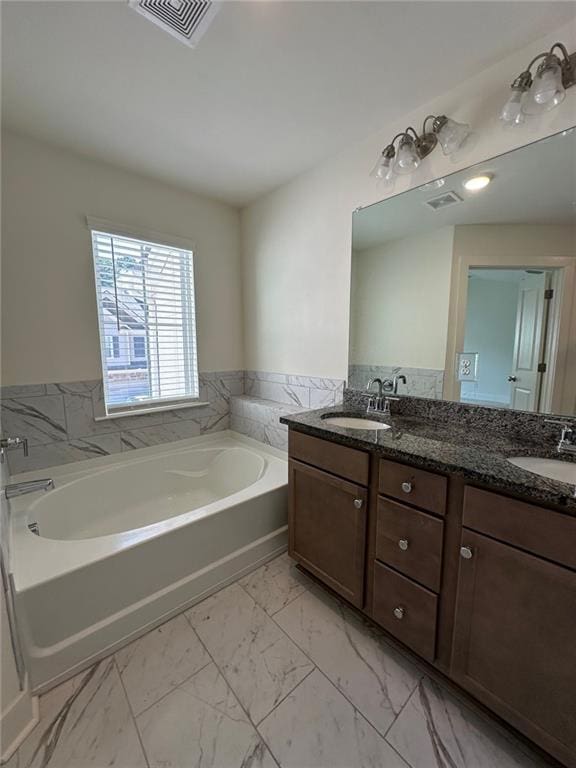 bathroom featuring vanity, a tub to relax in, and tile walls