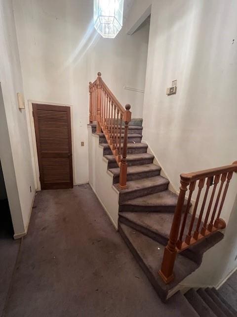 staircase with carpet floors and a high ceiling