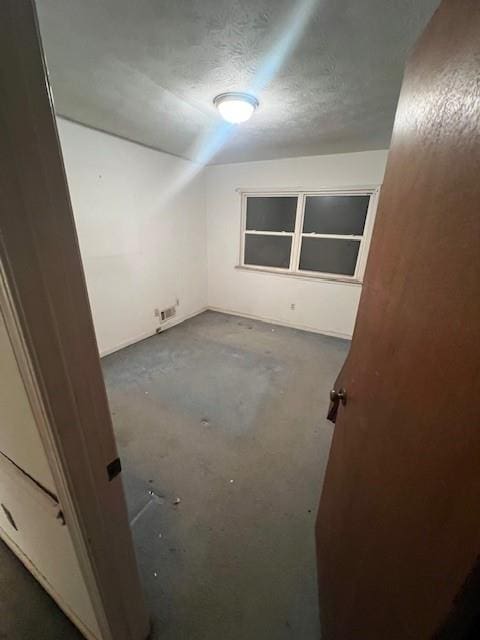 bonus room with a textured ceiling