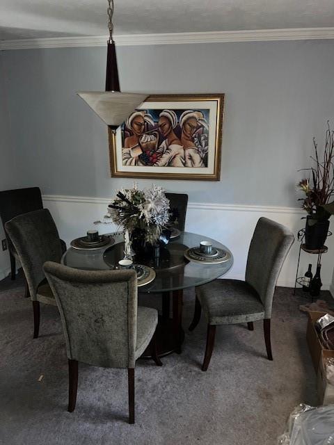 carpeted dining area featuring crown molding