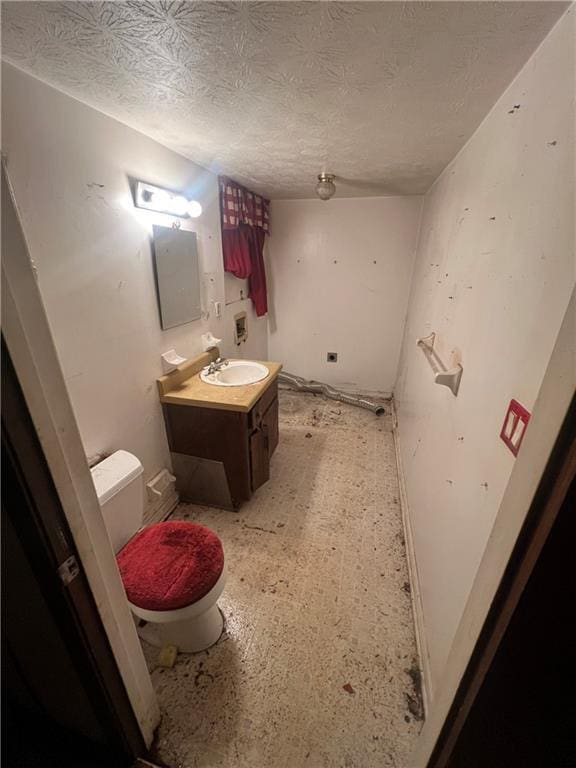 bathroom with vanity, a textured ceiling, and toilet