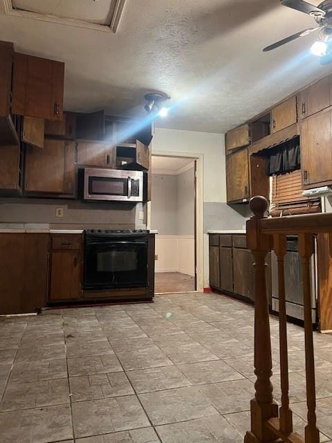 kitchen with ceiling fan, black stove, and a textured ceiling