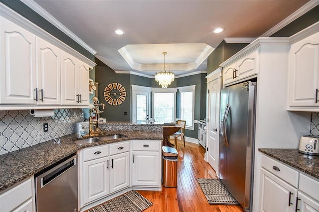 4742 Thunder River Dr, Gainesville, GA 30506 - kitchen with stainless steel appliances, white cabinetry, light wood-style floors, decorative backsplash, and a tray ceiling